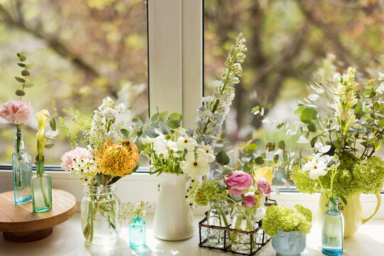 Various flowers with vase kept on window sill
