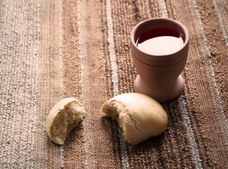 A bowl of wine and bread on the table. Communion symbols