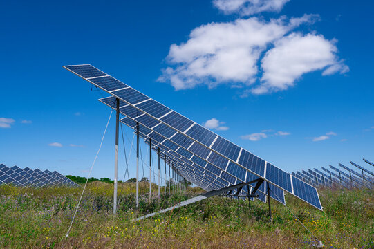 Solar panels station on field under cloudy sky