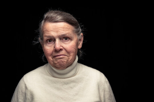 Senior woman with facial expression standing against black background
