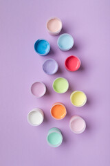 Pastel colors gouache in jars on table top view. Creative hobby painting concept.