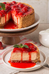 Slice of Classic baked Cheesecake  with a strawberry topping sauce. Homemade dessert. Vertical...