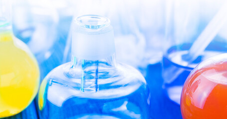 Laboratory glassware on blue background on sunlight