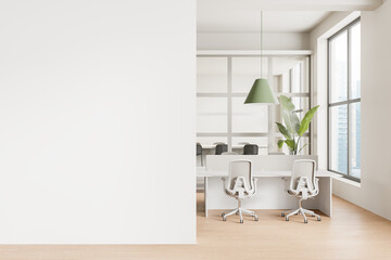 Modern office interior with white desks, chairs, green pendant lamp, and large windows, empty white...