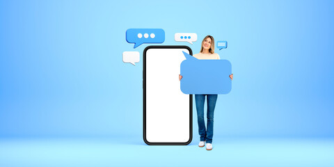 Young woman showing mock up speech bubble, smartphone with blank display