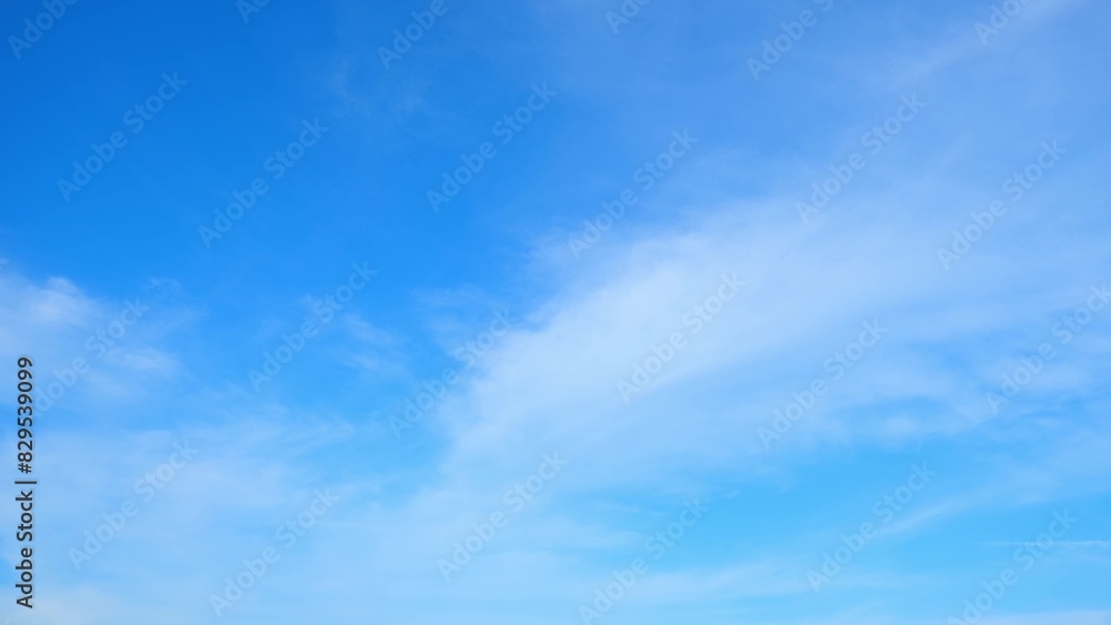 Wall mural a clear blue sky with a few wispy clouds scattered across it. the bright blue hue of the sky and the