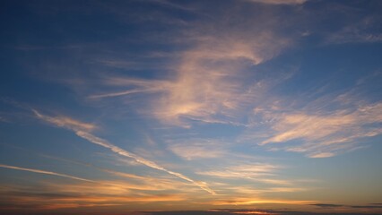 A serene sunrise with the sky transitioning from deep blue at the top to warm orange hues near the...