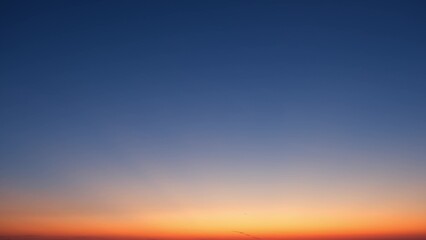 A serene sunrise with a gradient of colors from deep blue at the top, transitioning to lighter...
