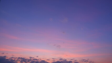 A beautiful sunset sky with soft hues of purple, pink, and orange blending seamlessly. The delicate clouds add a touch of texture to the serene evening scene. Sunset sky background.
