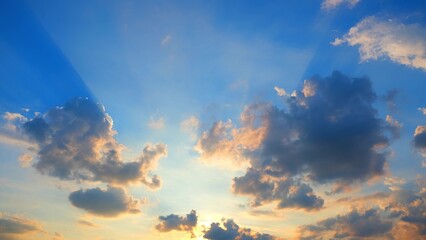 A stunning sky with dramatic clouds illuminated by the setting sun. The sunlight creates a...