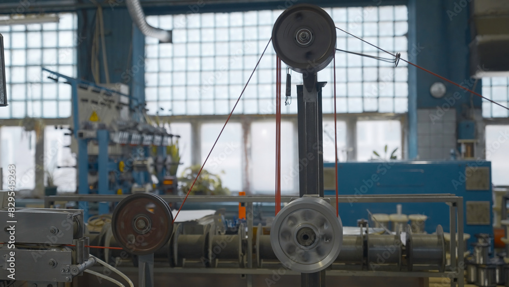 Aufkleber industrial machine with rotating coils and wire. creative. industrial winding of wires and cables on