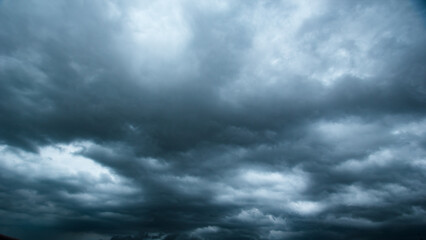 The dark sky with heavy clouds converging and a violent storm before the rain.Bad or moody weather sky and environment. carbon dioxide emissions, greenhouse effect, global warming, climate change.