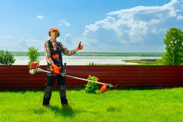 Portrait happy gardener man worker with petrol trimmer, showing thumb up.