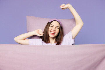 Young calm woman wear pyjamas jam sleep eye mask rest relax at home lay down on pillow cover with...