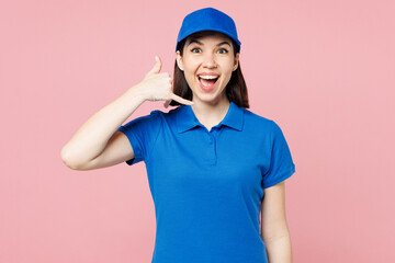 Professional delivery girl employee woman wear blue cap t-shirt uniform workwear work as dealer courier doing phone gesture like says call me back isolated on plain pink background. Service concept.