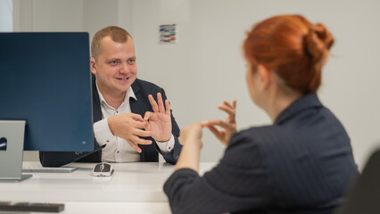Business partners communicate in sign language. A deaf boss gives a task to a subordinate woman.