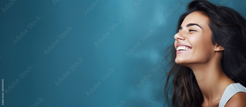 Aufkleber a smiling woman in a studio setting with a blue background displaying charming emotions suitable for