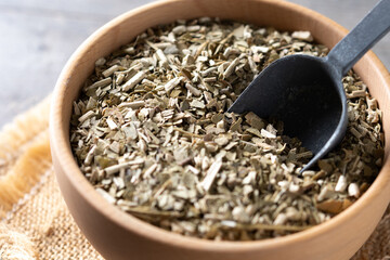 Traditional yerba mate in bowl on wooden table