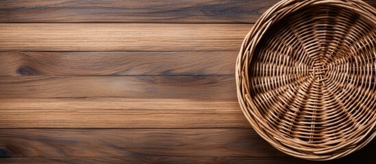 Top view of a wicker basket on rustic wood background with copy space image