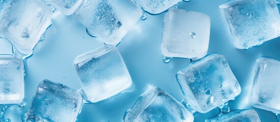 Top view of ice cubes with water droplets on a blue surface with copy space image - Powered by Adobe