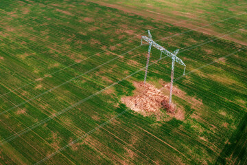 Transmission tower with four electric wires from drone point of view, aerial view