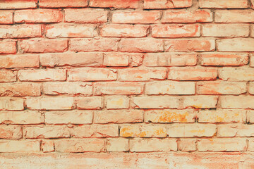 Old brick wall facade painted in peach fuzz color