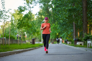 Athletic mature woman running in the park