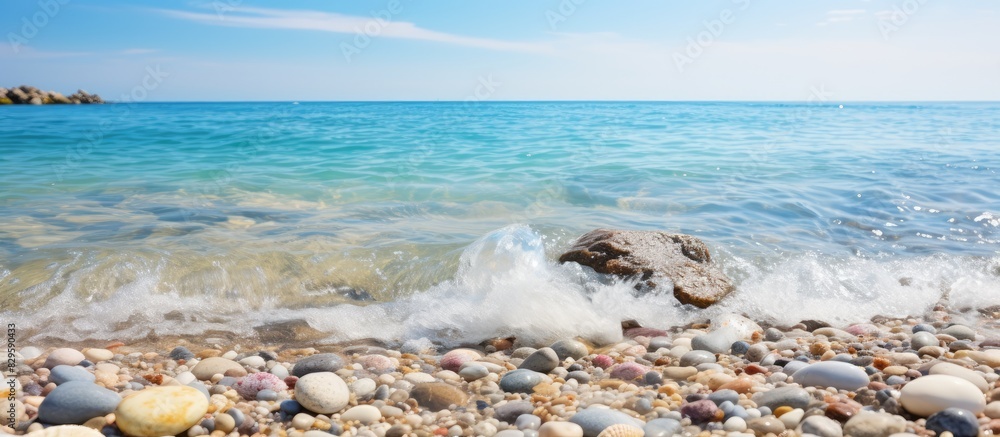 Poster sandy beach with colorful pebbles crystal clear waves gently foaming under the sun on a summer day w