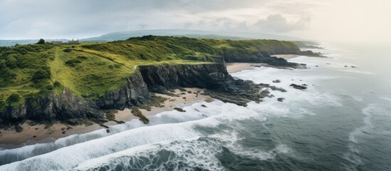Fototapeta premium A drone captured an aerial photo of a beach with rocks and vegetation on a cloudy day revealing a panoramic view of the sea coast with copy space image