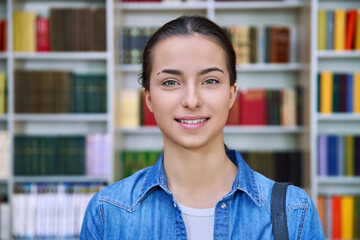 Headshot portrait of smiling teenage girl student, inside high school building