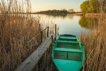 Old fishing boat moored in the reeds of the lake