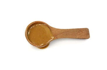 Sesame sauce in a wooden spoon isolated. Tahini isolated on white background