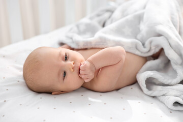 Cute little baby lying in crib at home