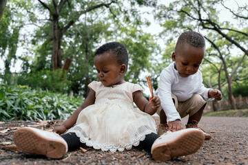 African sister and brother playing in a park path