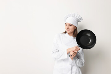 Professional chef with frying pan on light background. Space for text