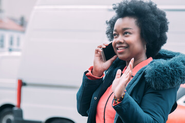 black woman talking on the phone in the street