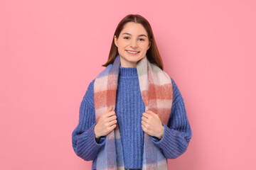 Beautiful woman in warm scarf on pink background