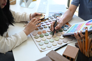 Cropped shot Interior designer helping client choosing colors in swatches palette for apartment...