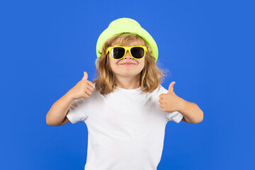 Funny summer fashion kid boy with thumb up. Child showing thumbs up on studio isolated background....