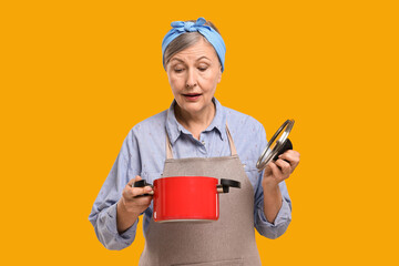 Housewife with pot and lid on orange background