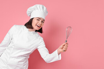 Naklejka premium Happy confectioner with whisk on pink background, space for text