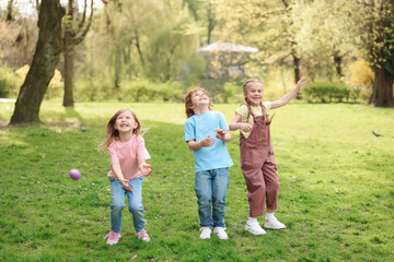 Obraz premium Easter celebration. Cute little children hunting eggs outdoors