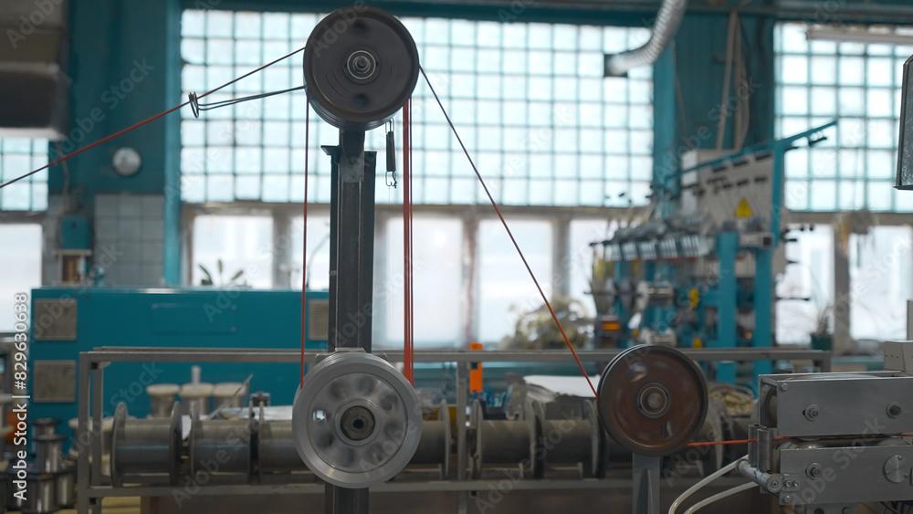 Poster industrial machine with rotating coils and wire. creative. industrial winding of wires and cables on
