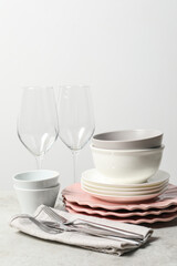 Beautiful ceramic dishware, glasses and cutlery on light grey table