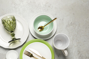 Beautiful ceramic dishware, cup, glass and cutlery on light grey table, flat lay