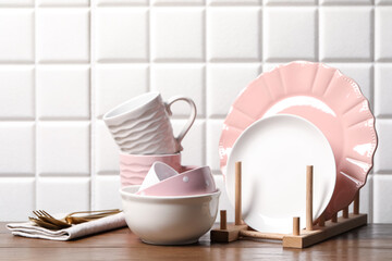 Beautiful ceramic dishware, cups and cutlery on wooden table