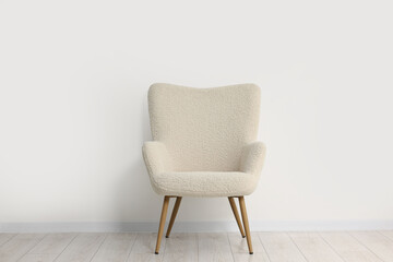 Fototapeta premium Comfortable armchair near white wall in room