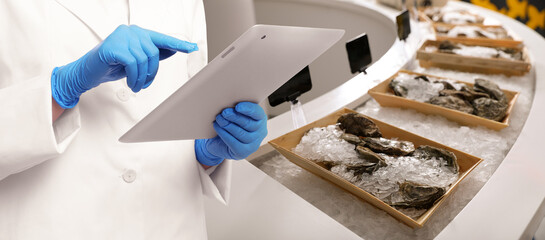 Food quality control specialist examining oysters in supermarket, closeup. Banner design