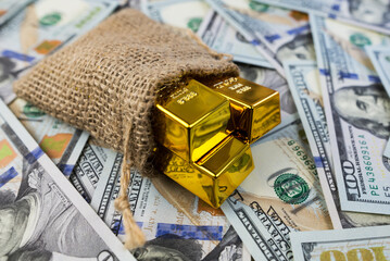 gold bars in a bag on a money background.
