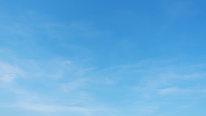 A clear blue sky with a few faint, wispy clouds. The sky is bright and expansive, suggesting a calm and pleasant day with excellent visibility. Horizon background.
